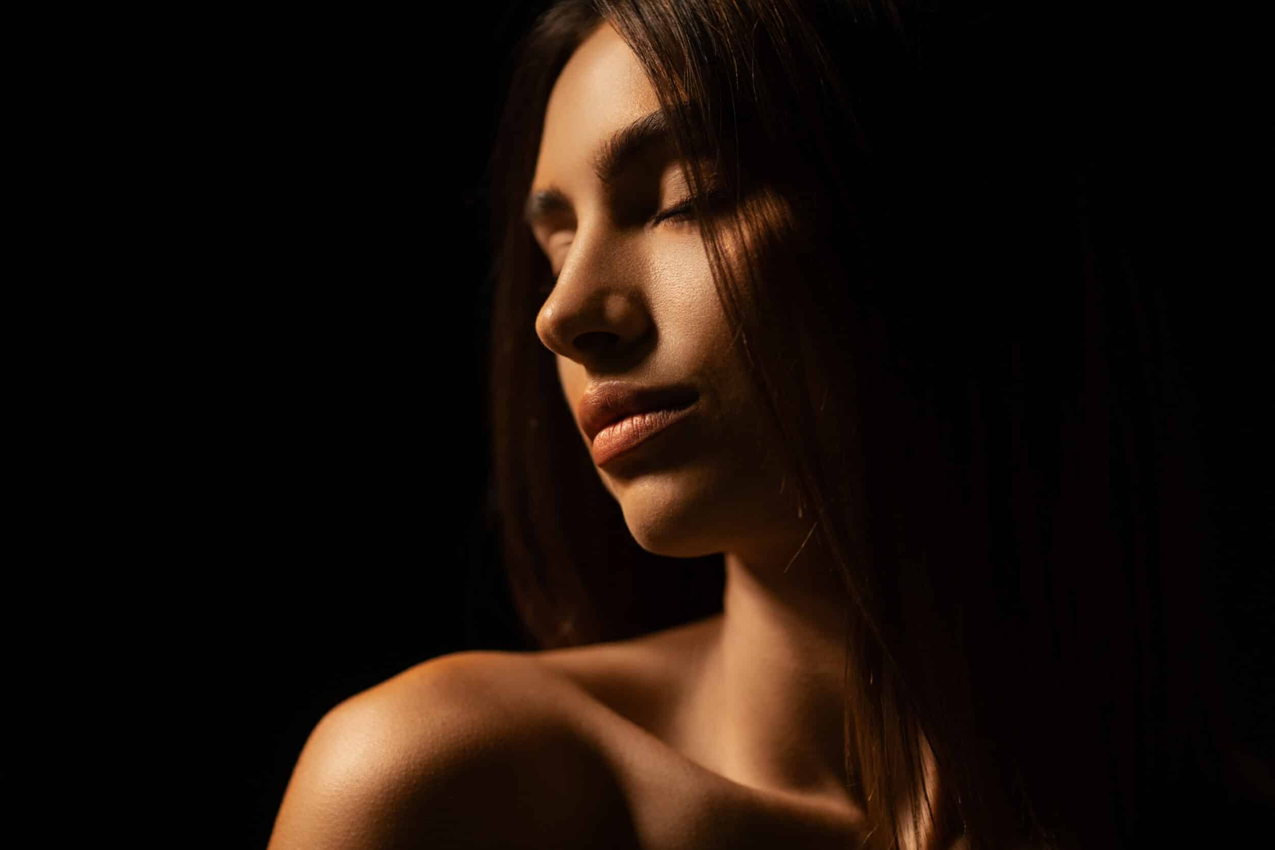 Portrait of beautiful woman over dark background