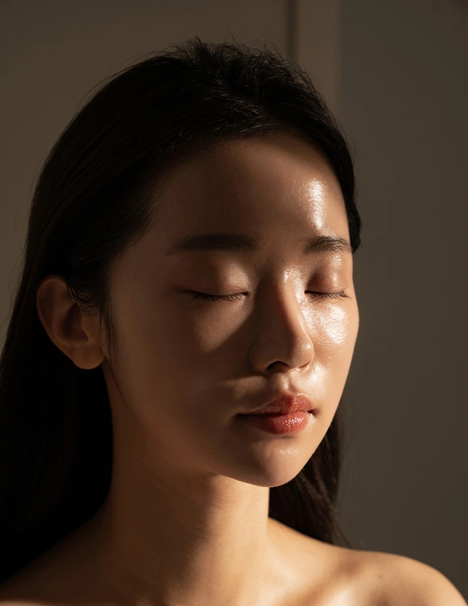 Woman with eyes closed in natural sunlight casting shadow across face in peaceful moment - IPL in Evansville, IN